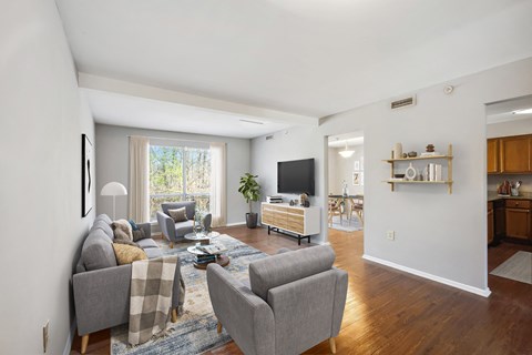 a living room with couches and chairs and a tv at Villages at Morgan Metro, Landover