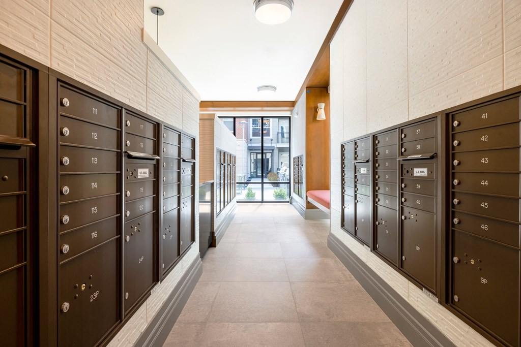 a hallway with brown lockers and a glass door at the end of the hallway