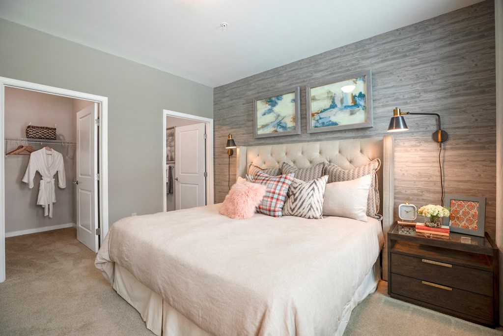 a bedroom with a bed and two paintings on the wall