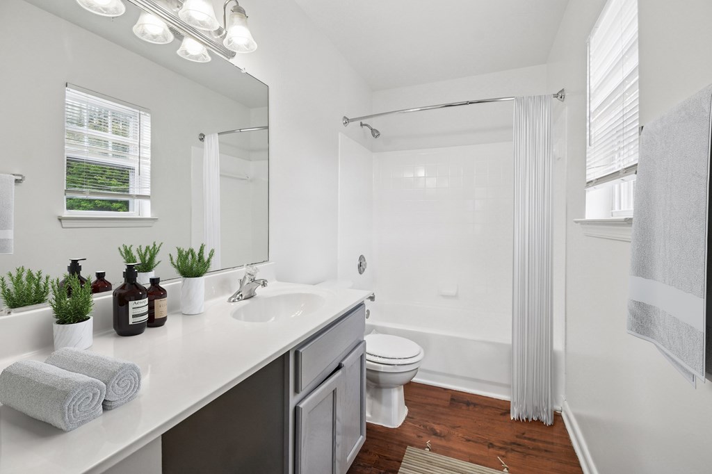 A white bathroom with a towel on the counter.