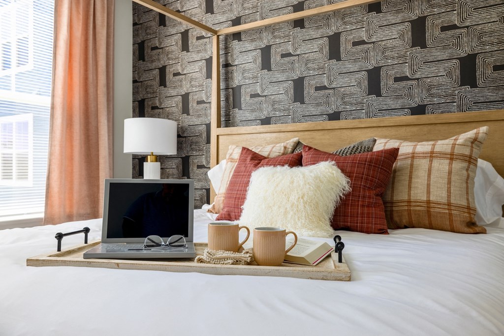 The Forge bed with a tray with a laptop and pillows on it