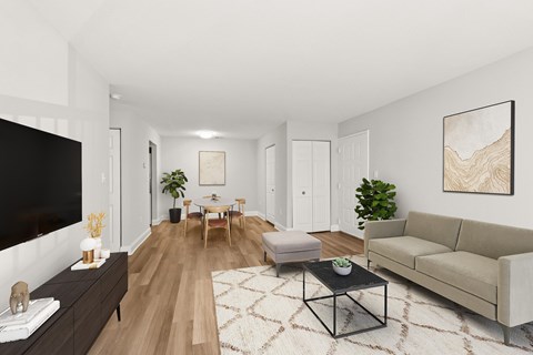 A living room with a black TV, a wooden floor, and a large painting on the wall.
