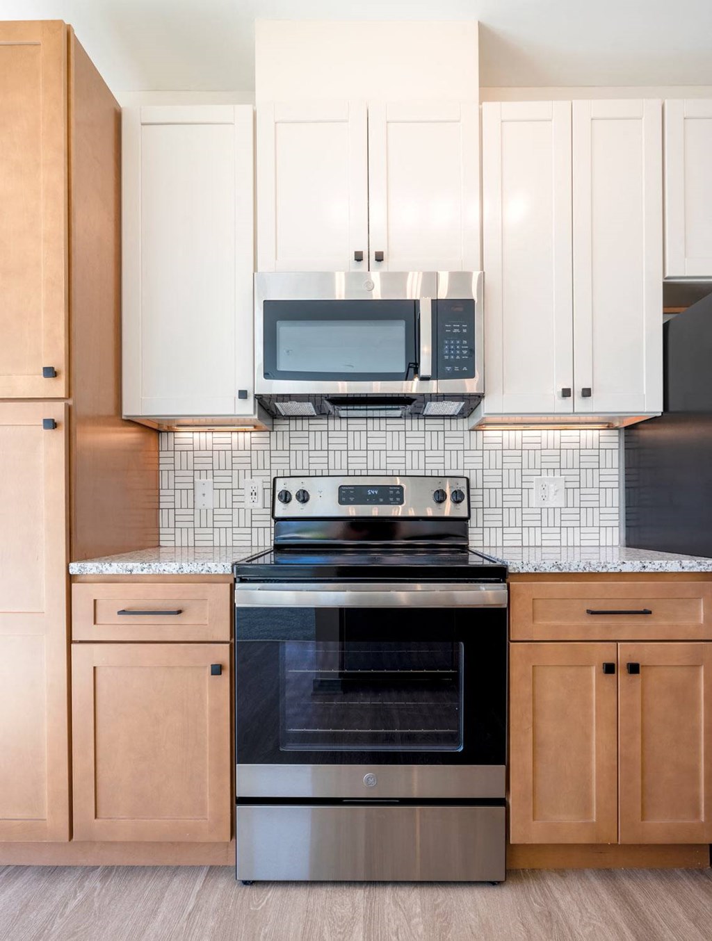 a kitchen with white cabinets and a black stove top oven