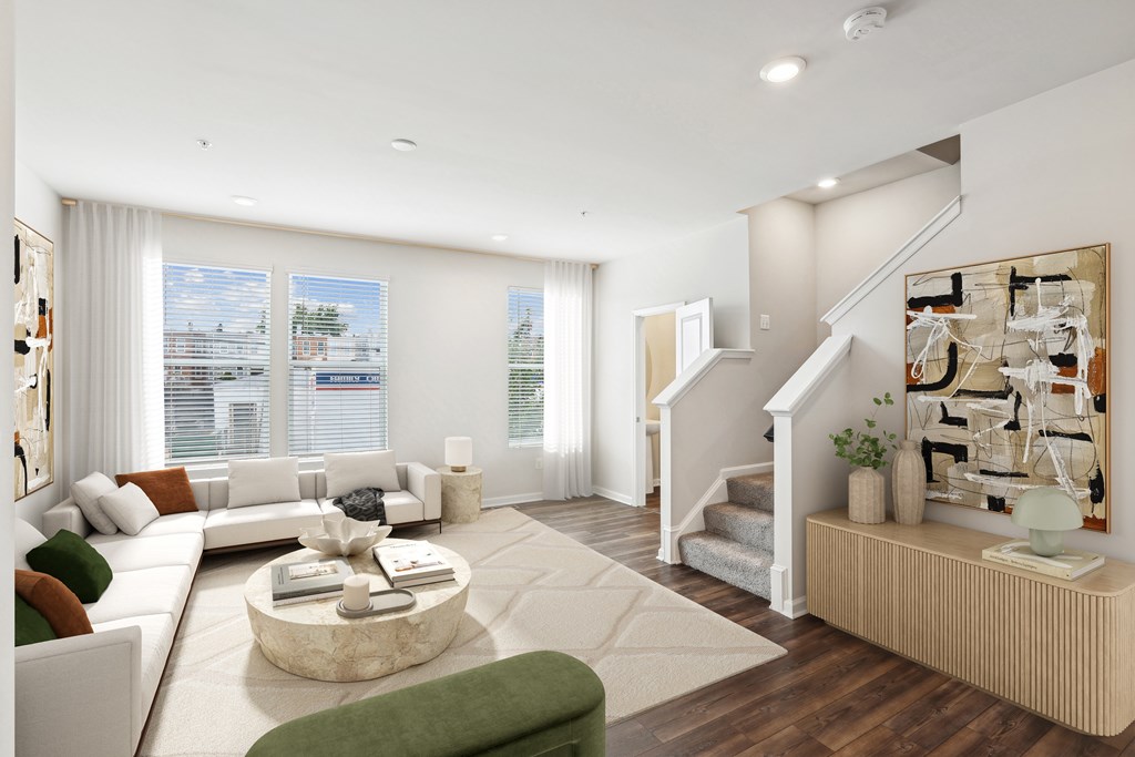 a living room with a white couch and a staircase at Refinery Row, MD 21224