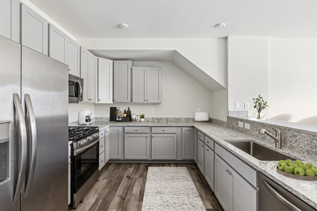 a large kitchen with stainless steel appliances and granite counter tops