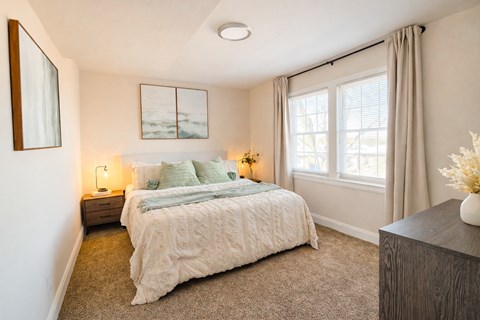 A bedroom with a large bed and a painting on the wall ighland Ridge Apartments, Capitol Heights, MD, 20743