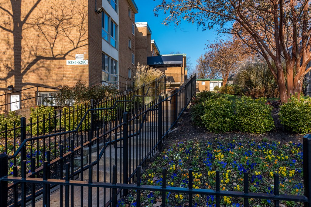 Apartment building with a fence and a garden in front of it at Meadows at Capitol Heights, Capitol Heights, MD, Maryland