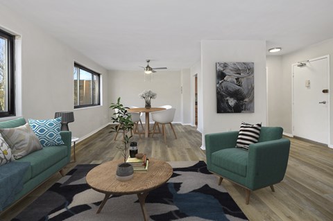 a living room with two green couches and a dining room table