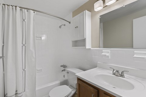 a white bathroom with a shower sink and toilet at Earle Manor Apartments, Wheaton, MD 20902