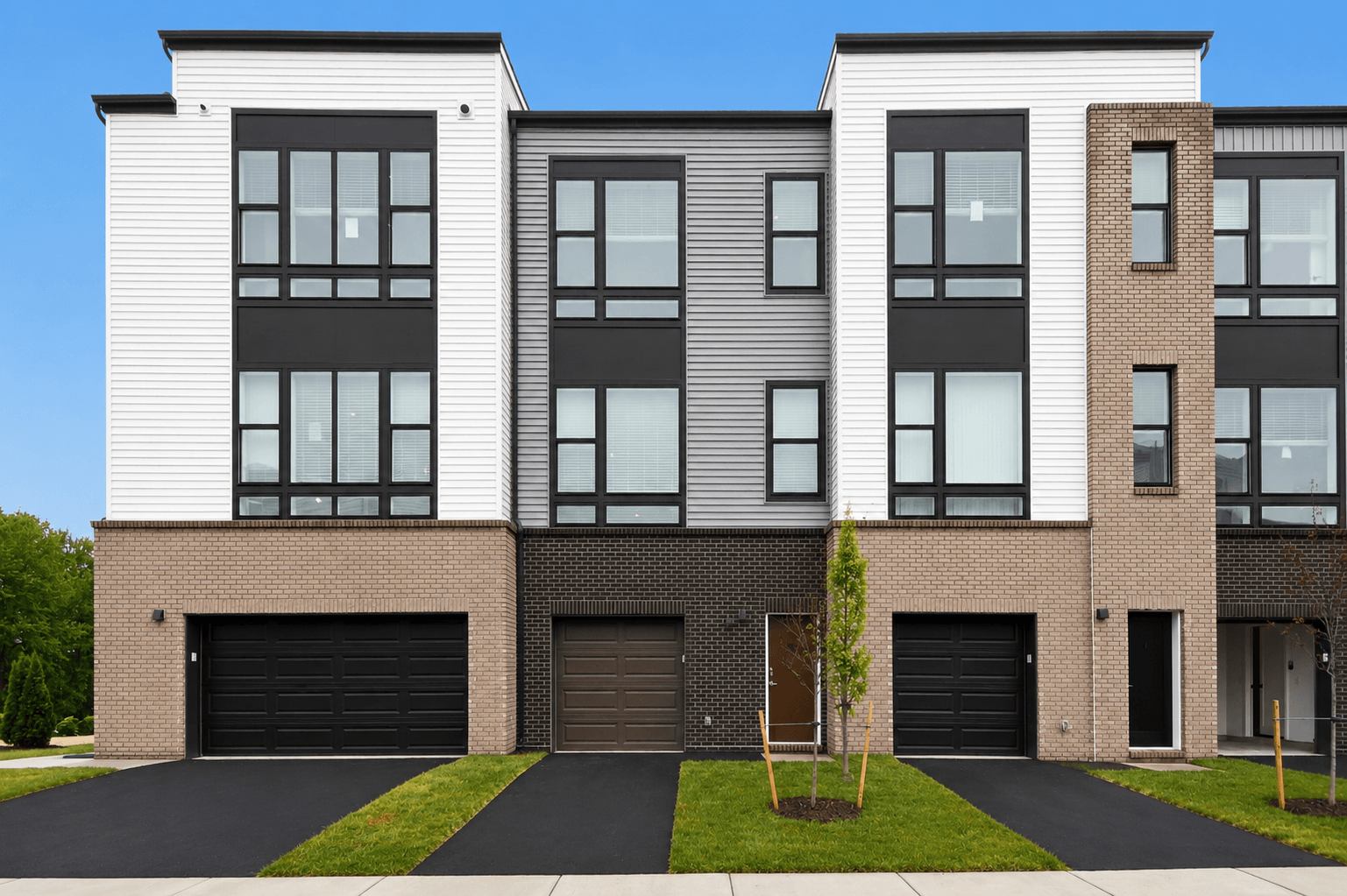 A modern two story building with a black garage door.
