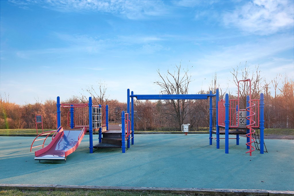 an empty playground with slides and a swing set at Villages at Morgan Metro, Maryland, 20785