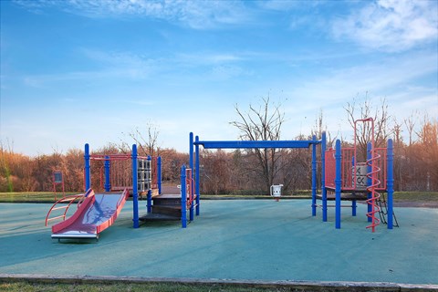 an empty playground with slides and a swing set at Villages at Morgan Metro, Maryland, 20785