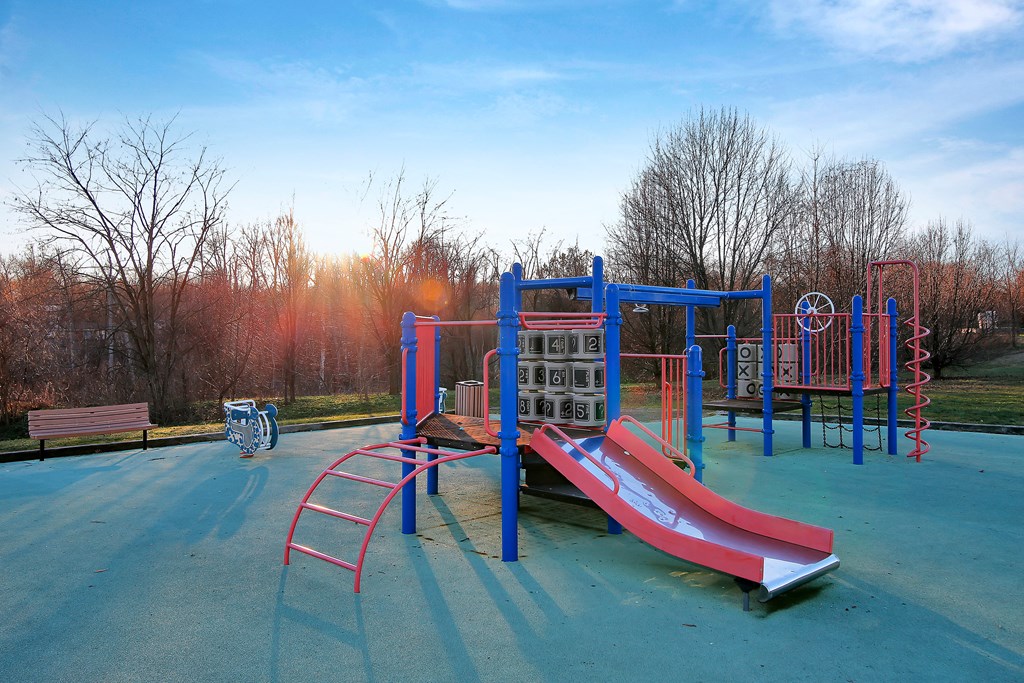 a playground with a slide and other equipment in a park at Villages at Morgan Metro, Landover