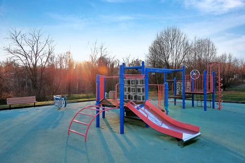 a playground with a slide and other equipment in a park at Villages at Morgan Metro, Landover