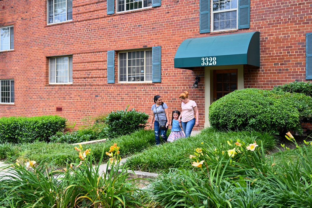 two women and a child walking in front of a brick building at Hamilton Manor Apartments, Hyattsville