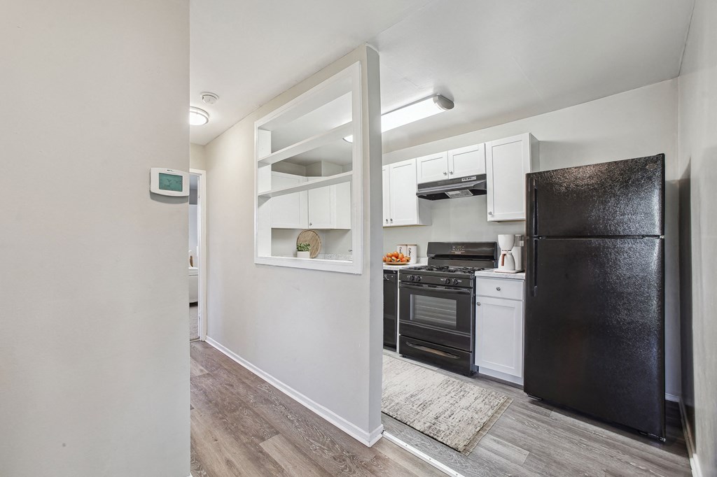 a kitchen with black refrigerator and stove and white cabinets at Laurel Pines, Laurel, Maryland, 20708