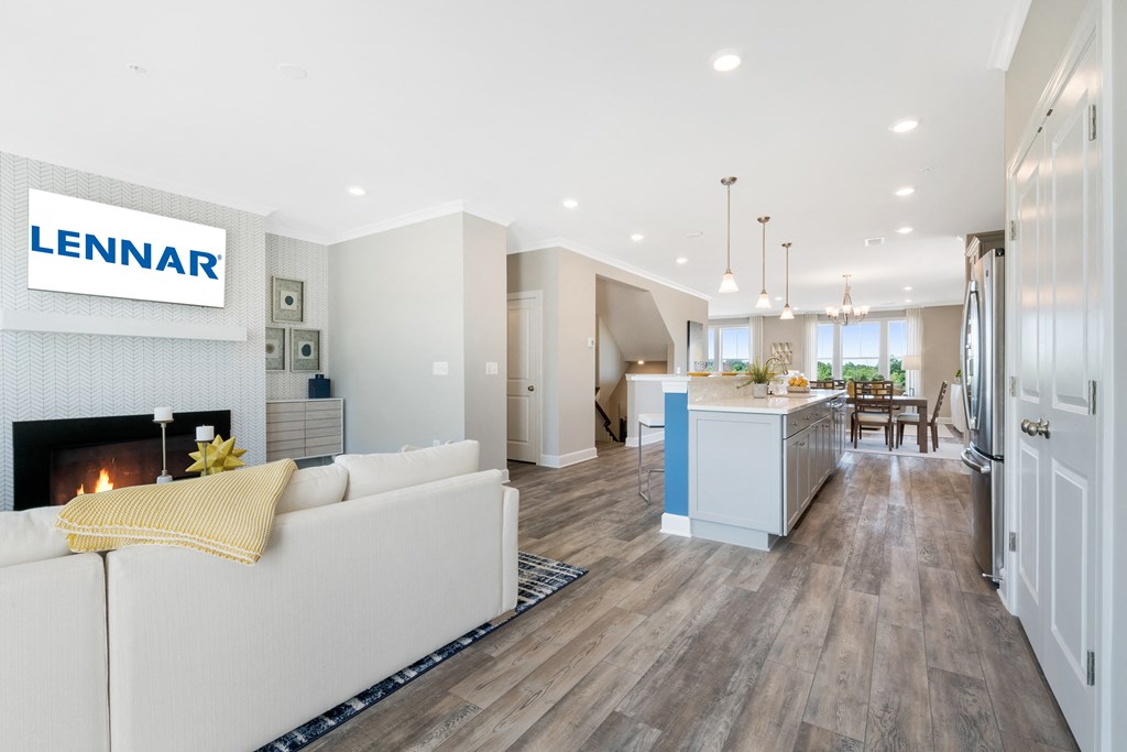 a living room with a white couch and a kitchen with a fireplace
