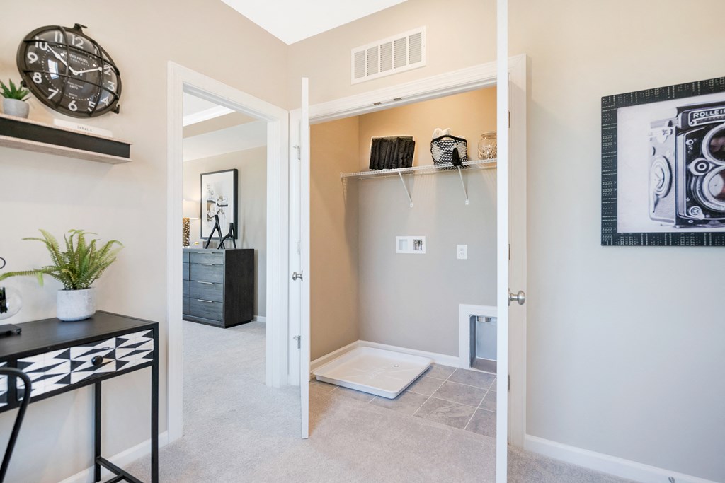 a hallway with a closet and a door to a room with a wall clock