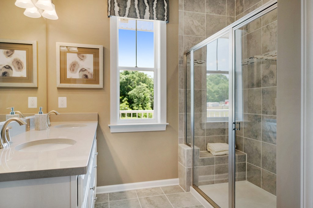 a bathroom with a shower and a sink and a window