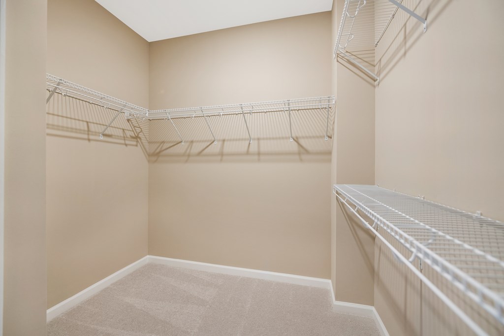 a spacious walk in closet in a home with empty shelves
