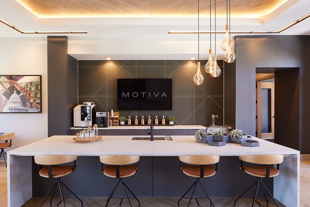 A modern kitchen with a large island and bar stools.