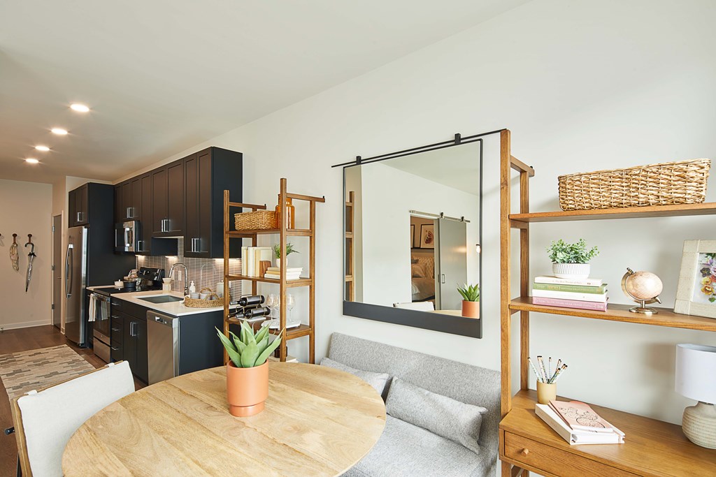 A modern kitchen with a dining table and a living area.