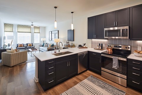 A modern kitchen with dark wood cabinets and stainless steel appliances.