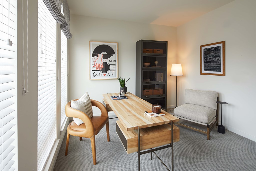 A room with a wooden table, a chair, and a lamp.