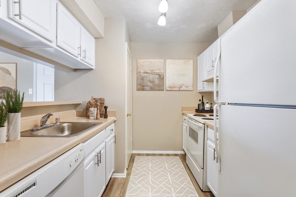 a kitchen with white appliances and white cabinets at Madison at Eden Brook, Columbia