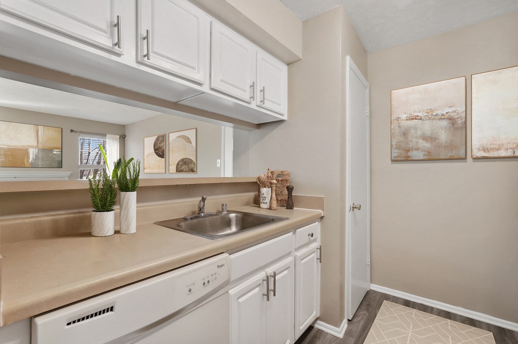 an empty kitchen with white cabinets and a sink at Madison at Eden Brook, 21046