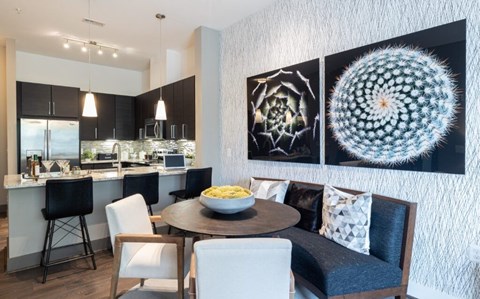A modern kitchen with a dining table set for four.