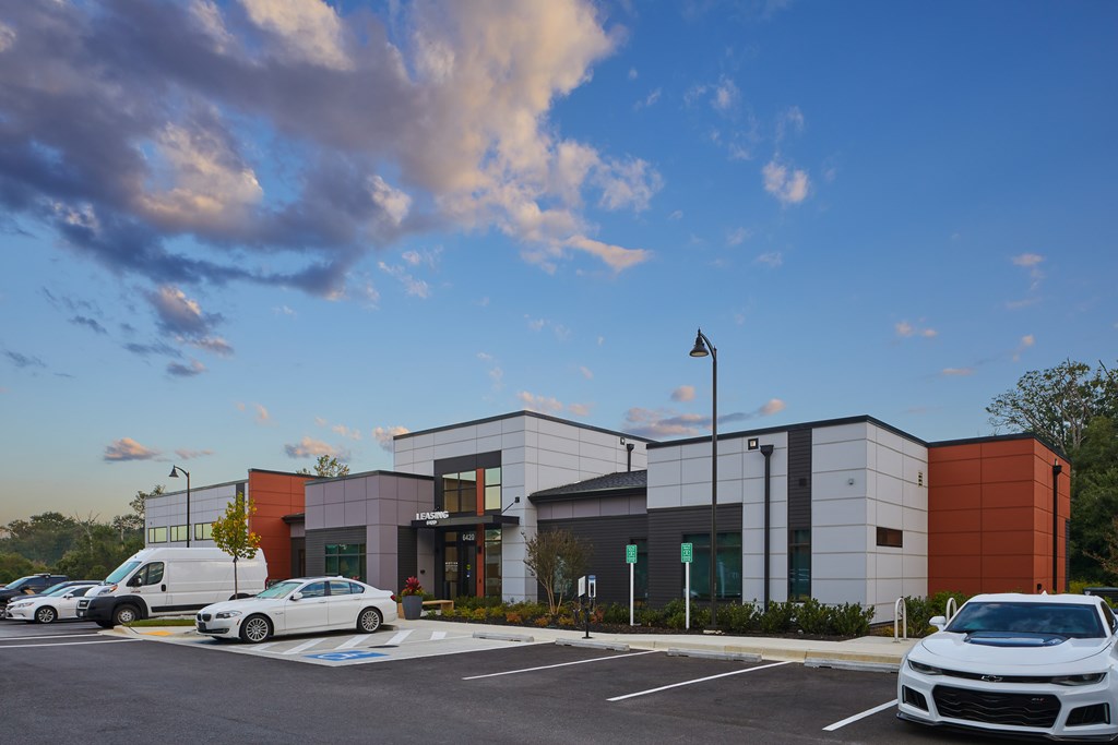 A modern building with a parking lot in front of it.