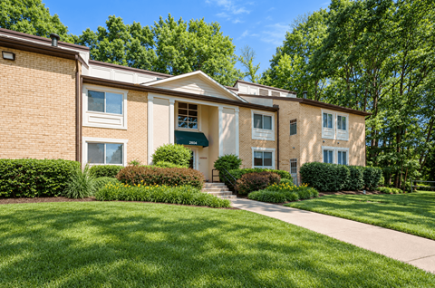 A building with a green lawn in front.