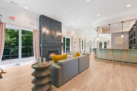 A living room with a grey couch and a fireplace.