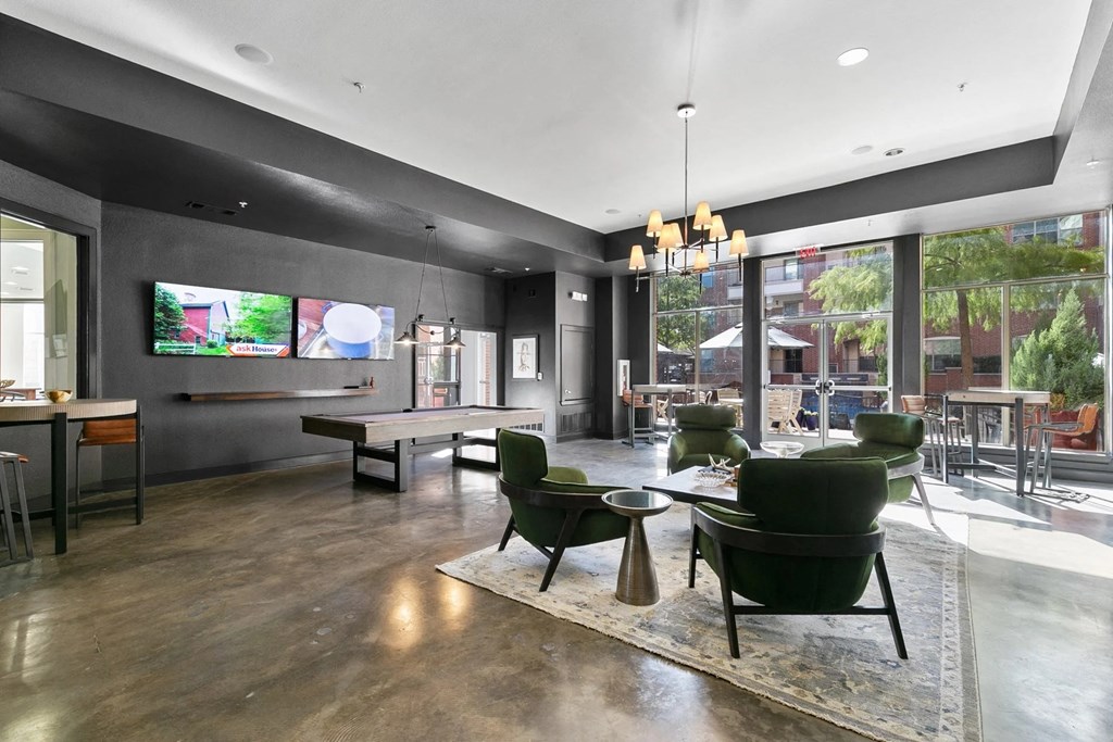 A modern living room with a large flat screen TV mounted on the wall at Prairie Crossing, Farmers Branch, TX 75244