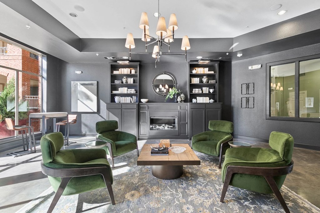 A modern living room with green chairs and a fireplace at Prairie Crossing, Farmers Branch, TX