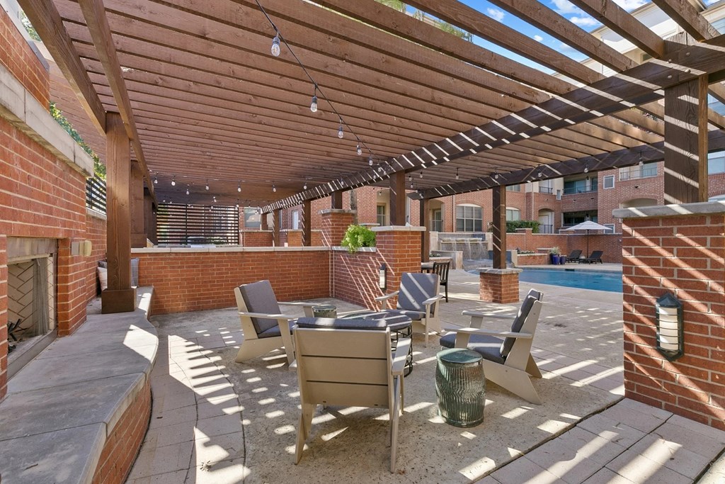 A patio with a table and chairs under a wooden pergola at Prairie Crossing, Texas 75244