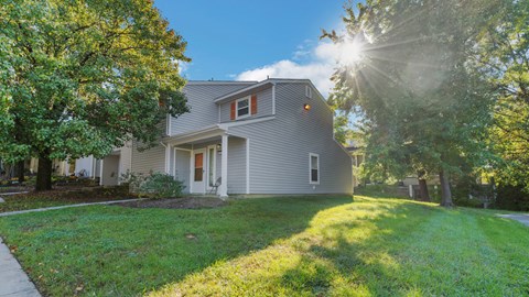 a gray house with the sun shining through the trees at Villages at Morgan Metro, Landover, MD