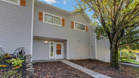 the front of a gray house with a sidewalk and a tree at Villages at Morgan Metro, Landover Maryland