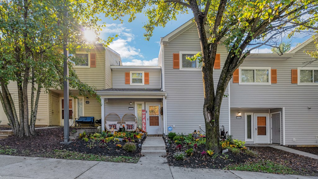 the front of a gray house with trees and a sidewalk at Villages at Morgan Metro, Landover, 20785