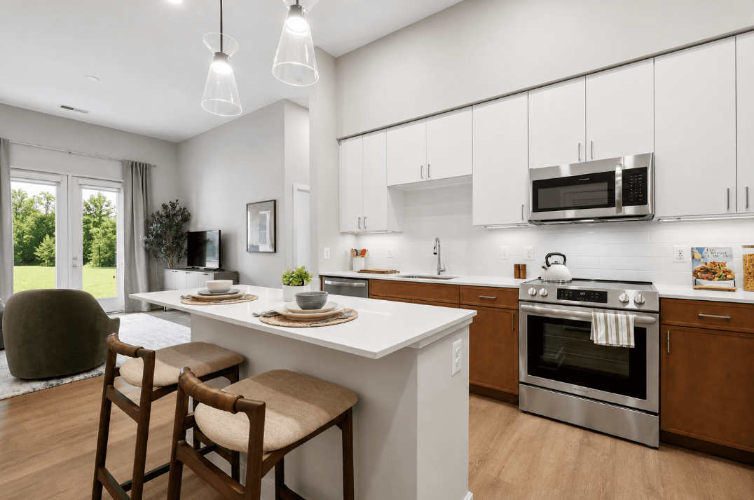 Modern kitchen and island with white countertops at The Terrace Apartments, Maryland, 21701