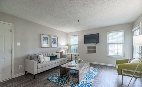 A living room with a couch, a chair, and a television.