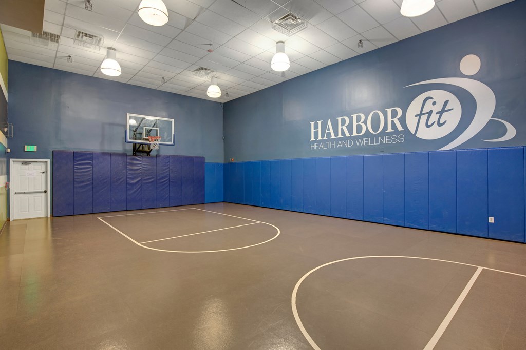 a basketball court in a room with a blue wall and a scoreboard at Villages at Morgan Metro, Maryland