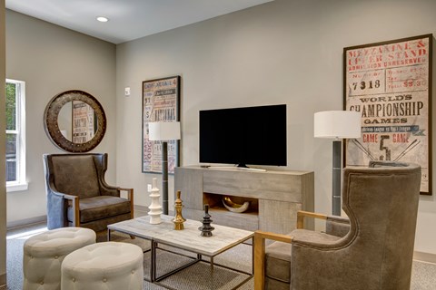 a living room with a fireplace and chairs and a television at Villages at Morgan Metro, Landover Maryland