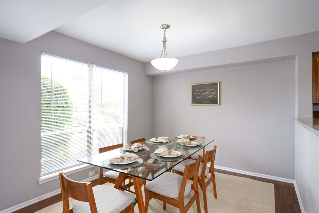 A dining room with a glass table and chairs.