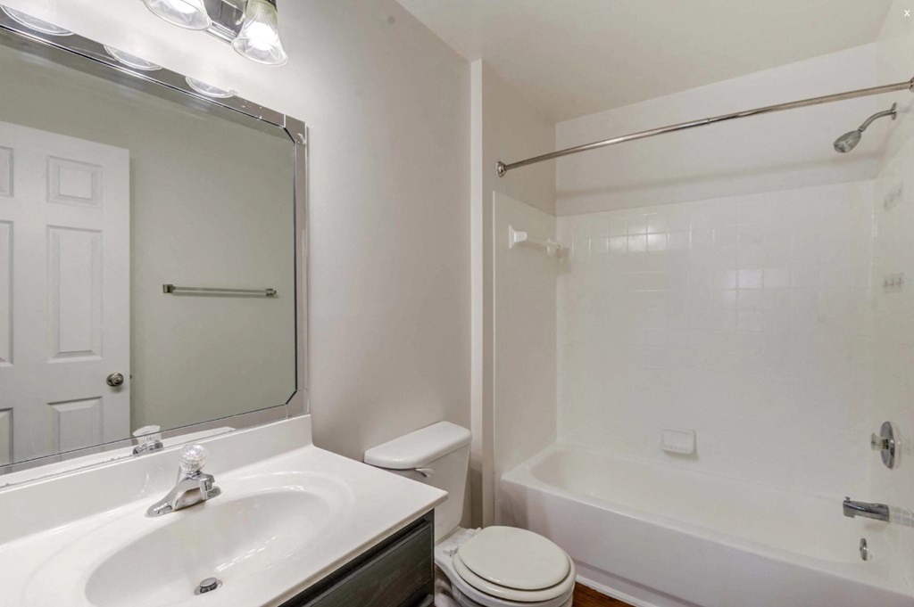 A white bathroom with a sink, toilet, and bathtub. at Park at Winterset Apartments, Owings Mills 21117