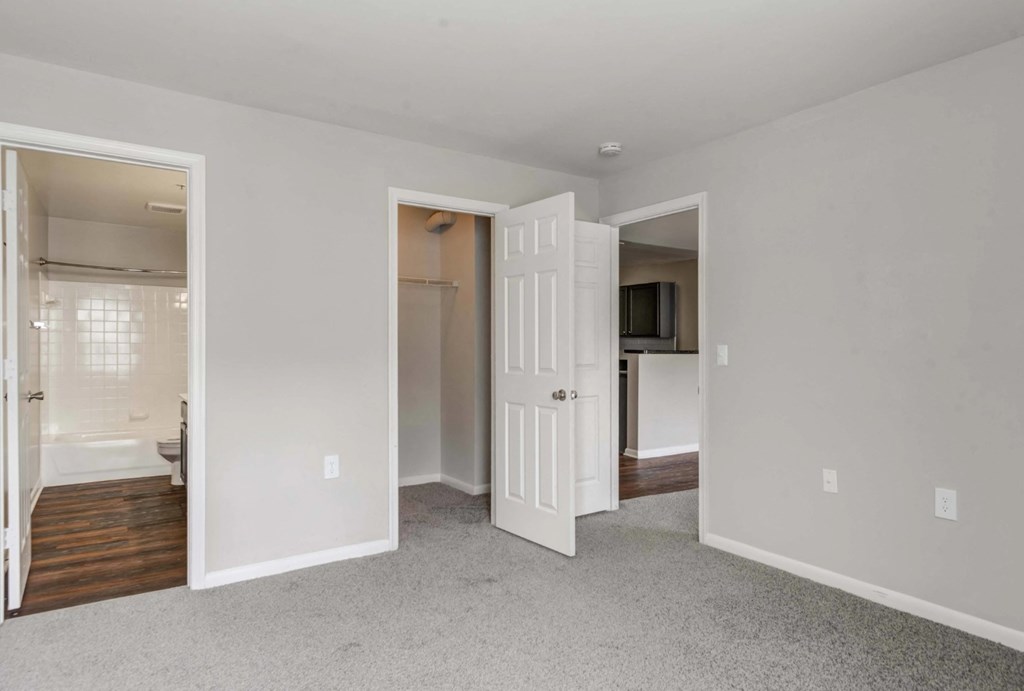 A white room with a carpet floor and a doorway leading to another room at Park at Winterset Apartments, Owings Mills, MD, 21117