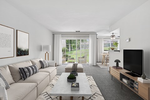 A living room with a white couch and a grey coffee table.