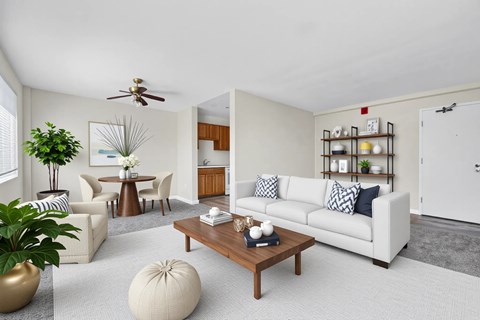 A living room with a white couch, a coffee table, and a ceiling fan at Highland Ridge Apartments, Capitol Heights, MD, 20743