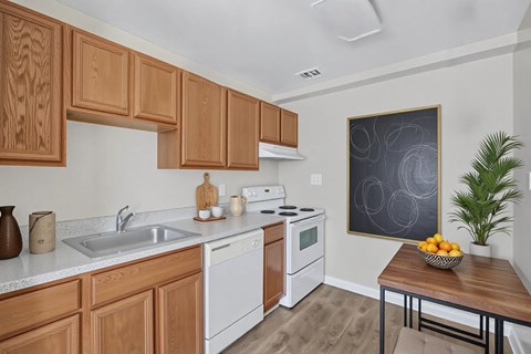 A kitchen with wooden cabinets and a white dishwasher at Highland Ridge Apartments, Capitol Heights